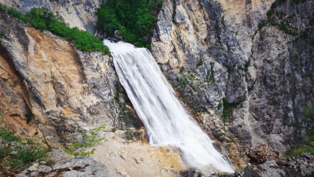 The powerful Boka Waterfall cascading down a tall rocky cliffside in Slovenia